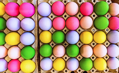 Multicolored easter eggs in egg tray. Creative Easter concept. Colorful handmade Easter eggs in paper container. Multicolored eggs in a cardboard egg carton. Egg in recycled basket protein breakfast.