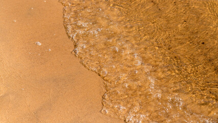 Wave on tropical sandy beach in summer background with copy space. Top view.