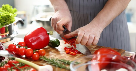 Male Hands Slicing Red Organic Pepper Ingredient. Man Chopping Vegetable to Small Slices on Wooden Cutting Board for Dieting Salad. Delicious Recipe of Vegetarian Food Horizontal Photography