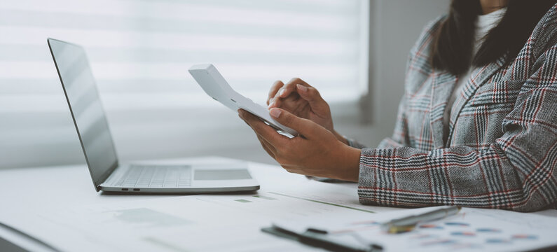 Confident Asian businesswoman working on laptop in modern office Accountants take care of finances, experts analyze business reports. Budget calculations on business growth files.