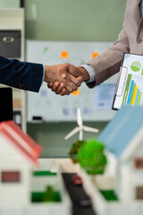 Businessmen shake hands after agreeing to start a new project successfully, renewable and...