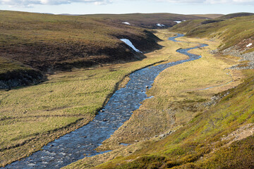 A small river runs through the vast landscape in the Varangerhalvøya National Park, Northern Norway