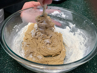 Mixing dough for cookies in a glass bowl.