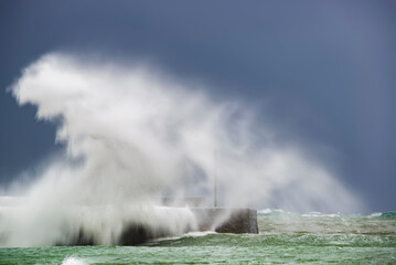 Large wave impacts the breakwater of Plentzia beach, Bizkaia during a storm in the Cantabrian Sea
