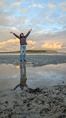 woman hiker backpacker enjoying coastal sunset scenery at sandy Silverstrand beach, Galway, Ireland, adventure and lifestyle concept, people in nature background