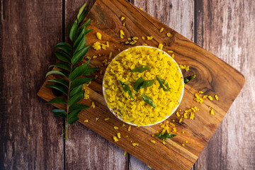 Traditional Indian Poha Dish with Curry Leaves on Wooden Board