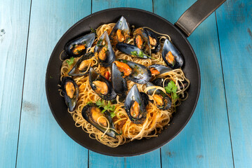Padella con deliziosi spaghetti conditi con cozze e bottarga di muggine, pasta italiana, cibo mediterraneo 
