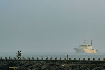 a ship and two girls running on a bicycle
