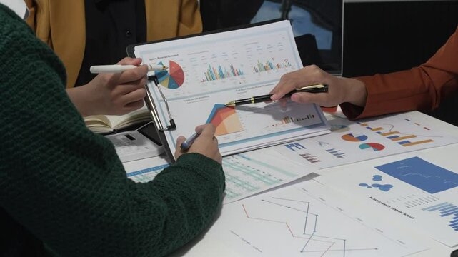 A group of people collaborates around a desk, discussing and reviewing user interface (UI) and user experience (UX) elements. usability, accessibility, and design principles for product development.