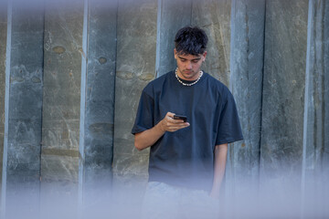 Obraz premium young man or teenager with mobile phone in summer on the street