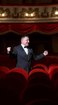 Comedian speaking in dark theater without people. Mad actor shouting in empty theatrical hall and calls someone. Consequences of pandemic. Vertical video
