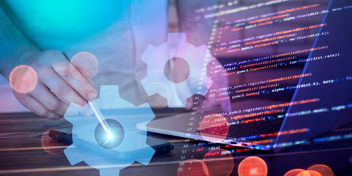 A programmer works with a laptop and writes program code. Software development concept.