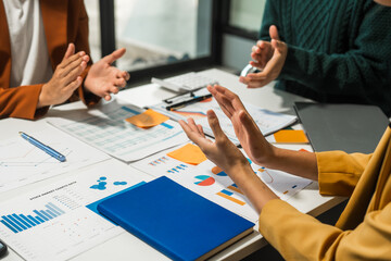 A group of people collaborates around a desk, discussing and reviewing user interface (UI) and user experience (UX) elements. usability, accessibility, and design principles for product development.