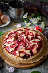 Sweet dessert for breakfast: strawberry pie on a wooden plate. Berry pie for breakfast. Vertical photo. Close-up