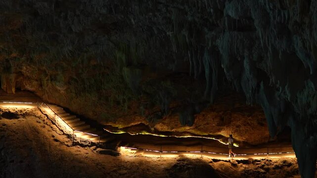 Girl tourist walks inside the Tham Luang Nang cave network in the north of Mae Sai in Thailand