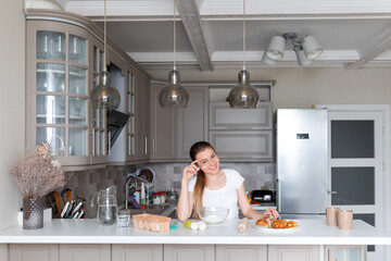 Young cheerful woman making bread, housewife girl cooking food in the kitchen