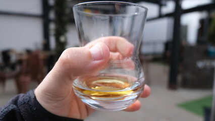 Close up of a person holding and toasting with a glass of whisky in Scotland UK 