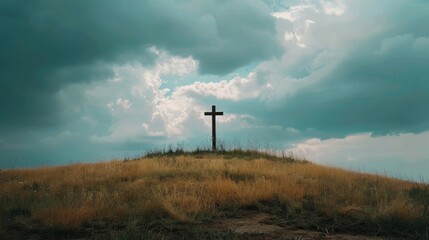 A solitary cross stands on a grassy hill under a dramatic, cloudy sky, symbolizing faith and spirituality in nature.
