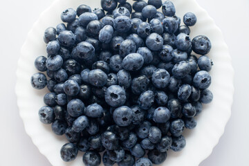 blueberries on a white plate. Blueberries top view. harvesting. healthy food and vitamins.