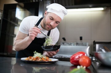 Chef cook in uniform cooking in the big cooker at the restaurant kitchen
