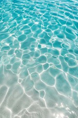 Top view of a blue, calm and clear water surface, water texture with ripples and relaxing background, summer concept. Turquoise water, beach sand bottom, with light ripples on the surface.