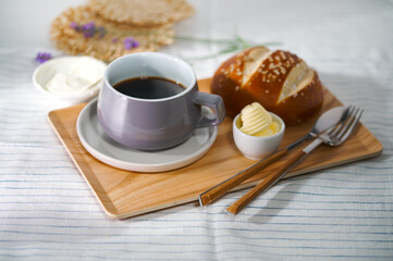 Cup of coffee with a pretzel roll for breakfast