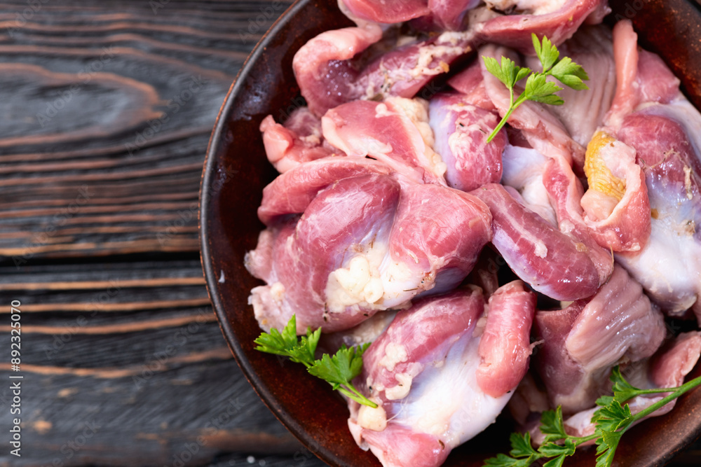 Poster raw chicken giblets gizzard ( stomach ) , meat background