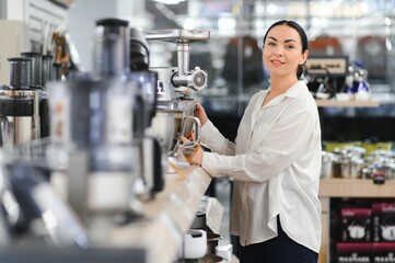 Woman choosing kitchen equipments at store