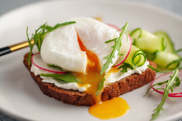 Open sandwich with vegetables and poached egg in a plate on the table
