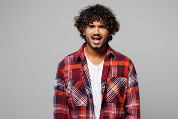 Obraz premium Young sad mad angry dissatisfied displeased disappointed grumpy Indian man he wearing red shirt casual clothes look camera isolated on plain grey color background studio portrait. Lifestyle concept.