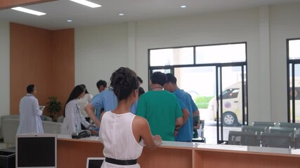 Group of healthcare professionals and clients at hospital reception. doctors wearing medical scrubs assisting patients. Multiracial team engaged in waiting area activities, health care business
