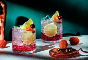 Lychee cocktail drink with vodka, soda, lime juice and ice, dark green background