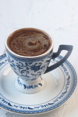 Turkish coffee in a blue cup on a white background