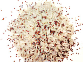 Top view of a heap of uncooked rice mix, comprising parboiled and basmati brown rice, and red quinoa, a product of bio agriculture, isolated on white background.