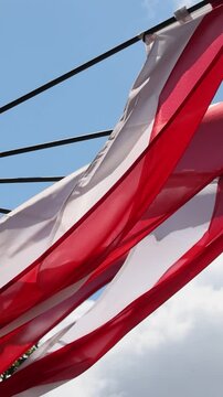 Flag of Monaco waving at wind against beautiful blue sky National Day of Monaco