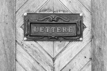  Detalle de un buzón clásico incrustado en una antigua puerta de madera en blanco y negro