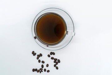Espresso Americano in a glass cup with fresh coffee beans scattered around Isolated White Background