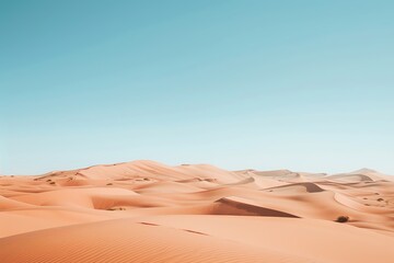 A vast desert landscape with rolling sand dunes under a clear blue sky.