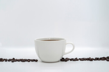 Espresso Americano in a ceramic fancy cup with fresh coffee bean scattered Isolated White Background