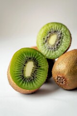 Fototapeta premium Fresh kiwifruit cut into two halves, displayed on a clean white surface for food photography or illustration