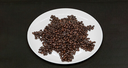 Isolated Plate with Healthy Dark Roasted Coffee Beans ready for Espresso Americano and Cappuccino