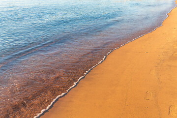Soft wave of the sea on the sandy beach.