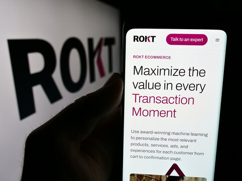 Stuttgart, Germany - 07-14-2024: Person holding cellphone with webpage of e-commerce technology company Rokt Pte. Ltd. in front of logo. Focus on center of phone display.