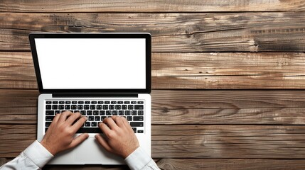Fototapeta premium A person typing on a laptop with a blank screen on a wooden table.