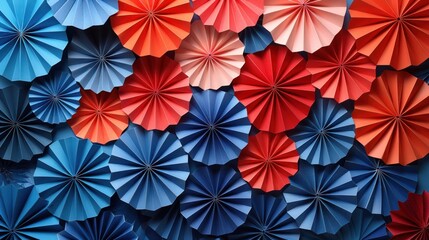 Naklejka premium Colorful paper fans in red, blue, and pink create a vibrant and cheerful wall decoration