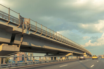 A long bridge with a yellow car driving on it