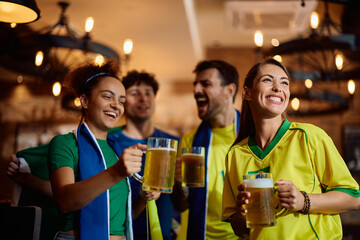 Group of happy sport fans drinking beer in  pub.