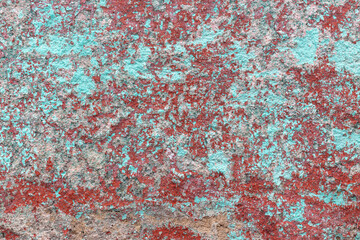 Grunge aqua and burnt red ochre peeling paint background texture. Abstract, vintage dappled backdrop for graphic design or social media. Chipped multi colour paint on external, rough concrete wall.