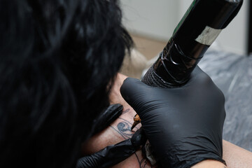 Plano cerrado usando maquina de tatuar en estudio de tatuajes