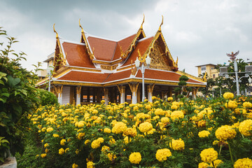 temple at lan khon muaeng in Bangkok with yellow flowers in the foreground